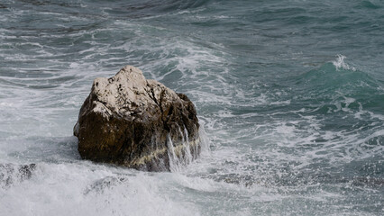 stormy mediterranean sea crushing over rock
