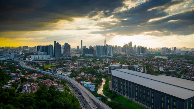 An establish aerial hyperlapse shot of Kuala Lumpur city overseeing the main four towers skyscrappers over a Middle Ring road highway