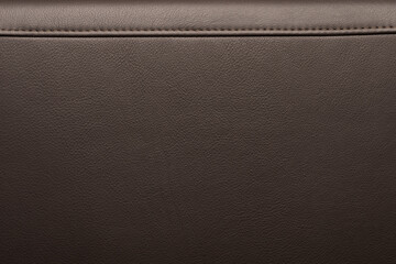 Texture of full grain brown leather with stitching on top