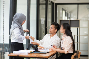 Asian business group discussing graph work at the office