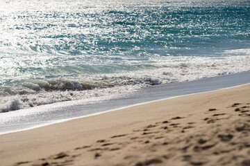 Waves rolling on a sandy beach on a sunny day