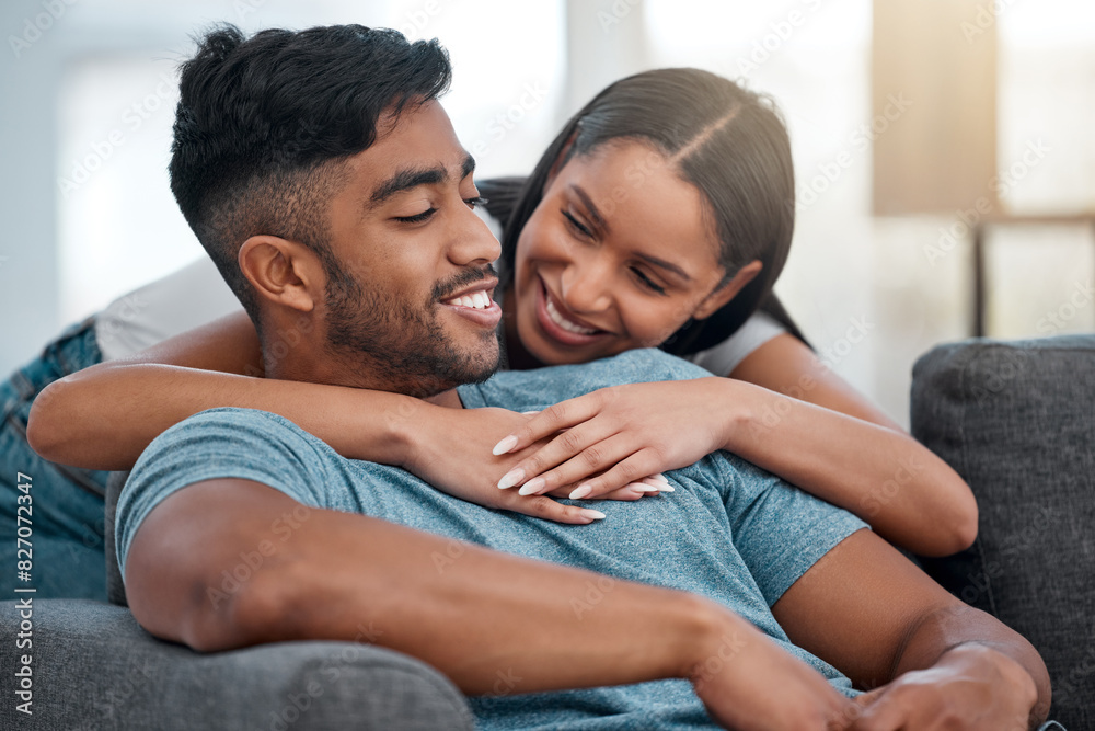 Sticker Couple, hugging and smile on sofa in home living room, bonding, relaxing and having fun. Support, man and woman on couch embrace in lounge for relaxation, happiness or enjoying love together in house