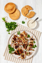 grilled mini pork skewers on a plate, top view