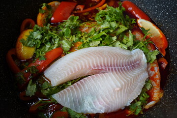Moroccan fish  with chermoula, red peppers and preserved lemon cooking process. Spicy traditional  Moroccan food