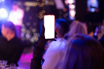 hand holding mobile smart Phone with a blank screen during a party, celebration, or in a nightclub....