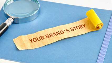 Business concept. Copy space. Concept words Your brands story on a note made of paper on a blue business notebook