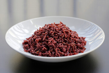 Cooked black berry rice on dark background.