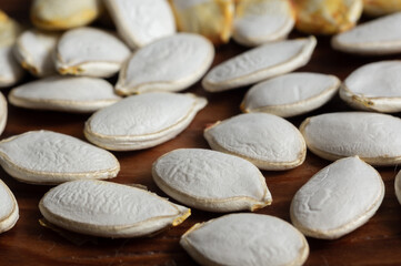 Pumpkin seeds on a wooden background. Vegetable garden concept