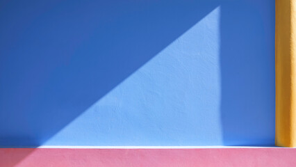 Colorful blue and pink exterior concrete wall with yellow column of vintage building in minimal style with sunlight and shadow on surface