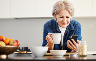 Senior woman, cellphone and happy for coffee in kitchen with video call and communication in...