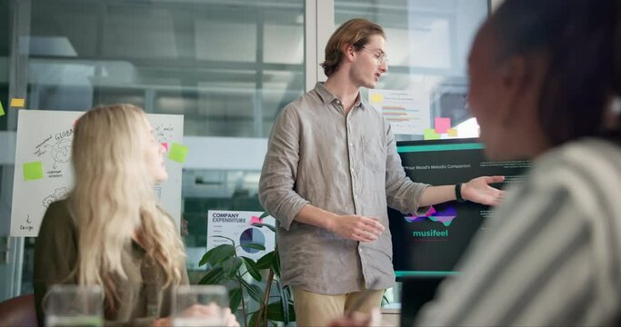 Businessman, meeting and presentation with screen for app, software development or mission at office. Young man, presenter or speaker talking to employees or team with display for function of project