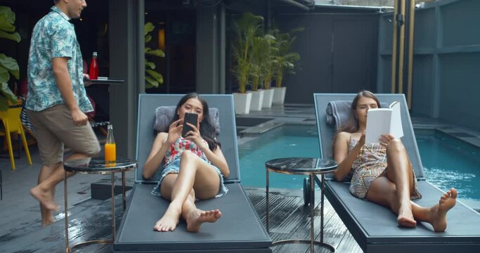 A group of tourist enjoys party and relax at pool bar in the hotel.