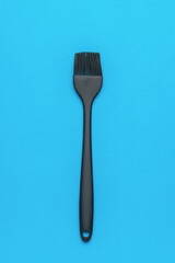 Modern Black Silicone Basting Brush on a Blue Background for Cooking and Baking