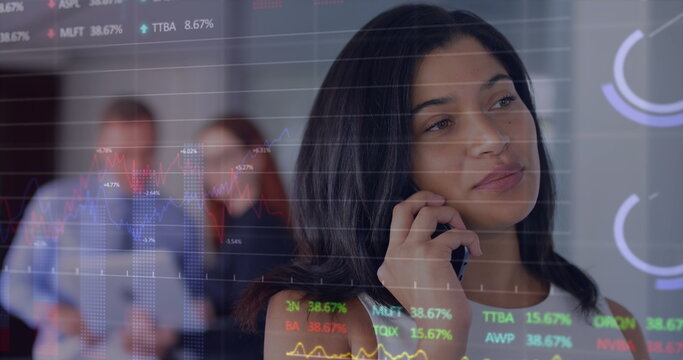 Image of graphs and trading board over beautiful biracial woman talking on smartphone - Powered by Adobe