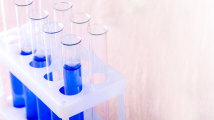 Set of test tubes with blue liquid on the desktop with copy space
