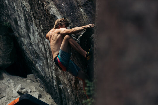 Muscular climber on a boulder in Magic Wood, Switzerland