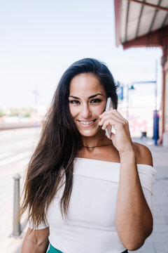Beautiful urban woman talking on mobile phone at street