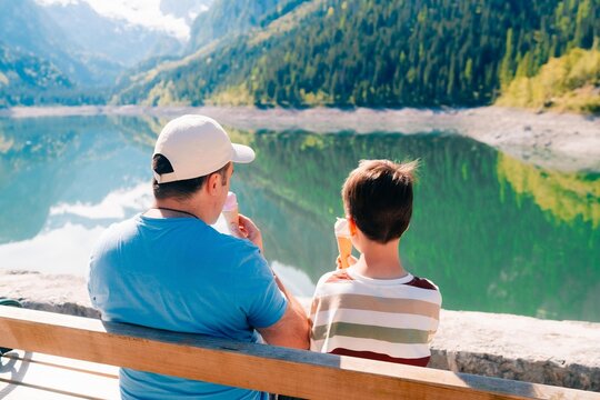 dad with son and ice cream in the mountains near a lake in summer