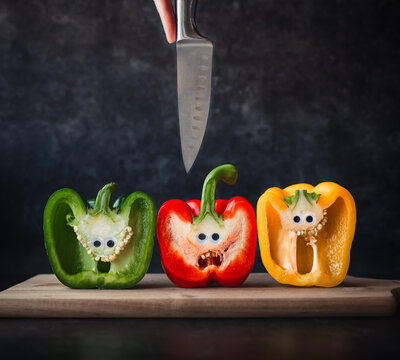 Funny image of scared bell peppers as knife comes at them from above.