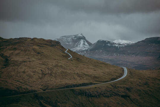 windy road alongside nordic mountains
