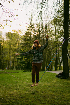 Athletic man trains on a slackline.