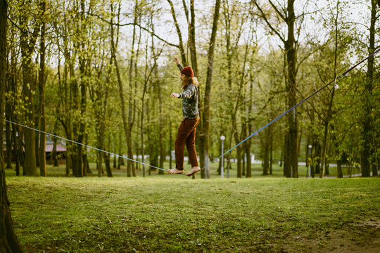 Athletic man trains on a slackline.