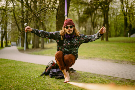 Athletic man trains on a slackline.