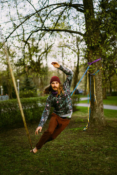Athletic man trains on a slackline.