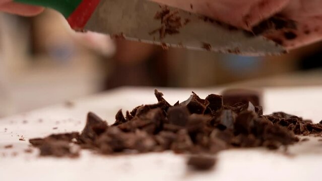 the pastry chef chops the chocolate for the birthday cake
