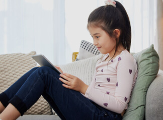 Child, tablet and online in home for e learning, reading and streaming video with education app....