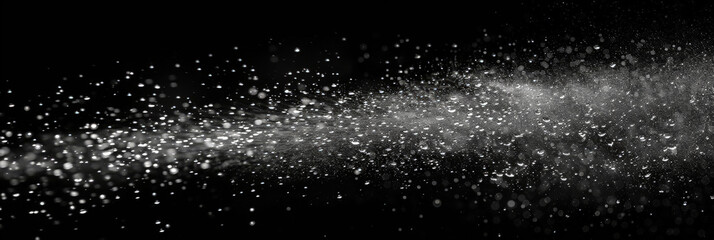 Obraz premium Water spray on black background, white water droplets falling in the air, particles of dust floating in space.Abstract black and white bokeh lights with sparkling particles creating a dramatic