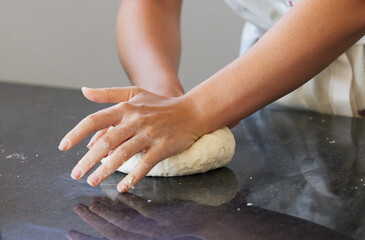 Person, hands and kneading dough in kitchen or baking bread for morning breakfast, cooking or...
