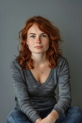 Fototapeta premium Woman With Red Hair Sitting on Floor