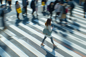 Woman crossing a busy street while checking her phone.