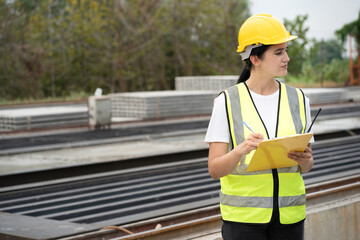 Portrait Hispanic latin engineer woman use clipboard checking precast cement at precast cement outdoor factory	