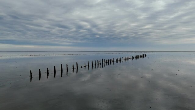 Aerial View: Wadden Sea near Wierum, Friesland, Netherlands with Wooden Posts and Stunning Cloud Reflections