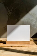 a mockup of a blank white postcard standing on a wooden table