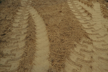 Machine Imprints in sand soil. Truck work machine wheel tracks in the sand