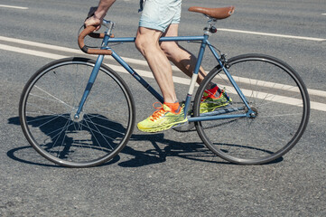 Hipster man rides on his  fixed gear bicycle on asphalt roadway