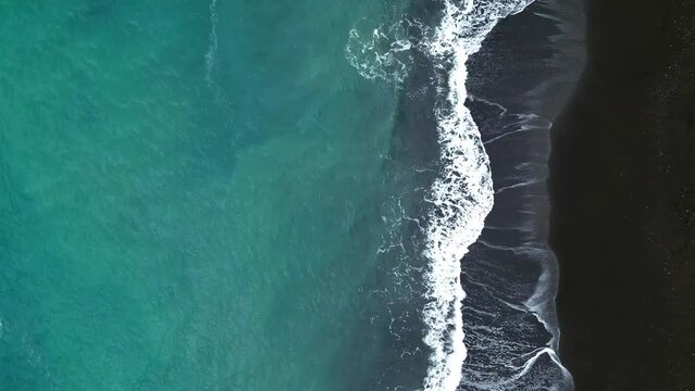 Horizontal Drone Shot of Black Sand Beach in Indonesia. Aerial View Top Down waves crushing. 