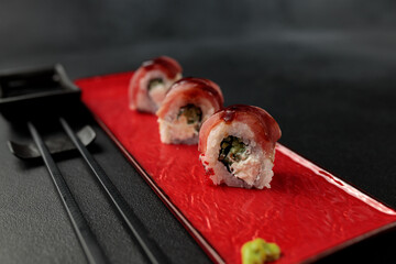Japanese food: sushi, roll with tuna, tiger shrimp, unagi, Philadelphia. Black background