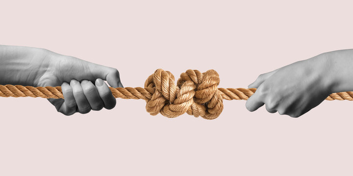 Two hands tie a knot in a rope. Tug of war. Two hands pull on a rope with a knot in the middle. Strong connections concept. Successful business deal. Competitive fight