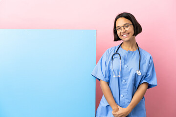 Young mixed race surgeon woman with a big banner over isolated background laughing