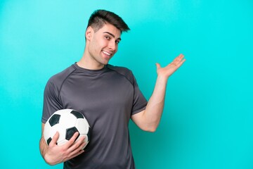 Young caucasian football player man isolated on blue background extending hands to the side for...