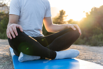 Closeup of an unrecognizable young man practising yoga exercises in nature