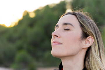 Close up portrait of a woman breathing fresh air. Inner peace
