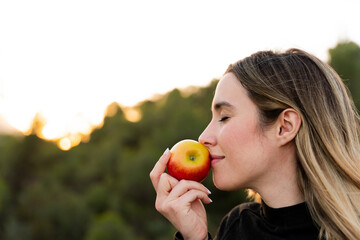 Woman smelling an apple. Nutrition and healthy diet
