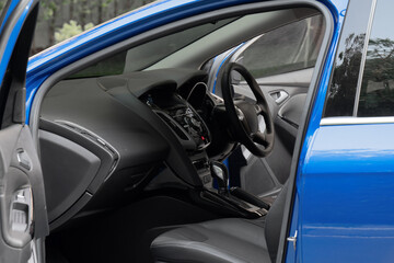 Side view of the open driver's door, glass, dashboard of the car. Front door left, right, new, modern, luxury car, there are a lot inside. modern car interior
