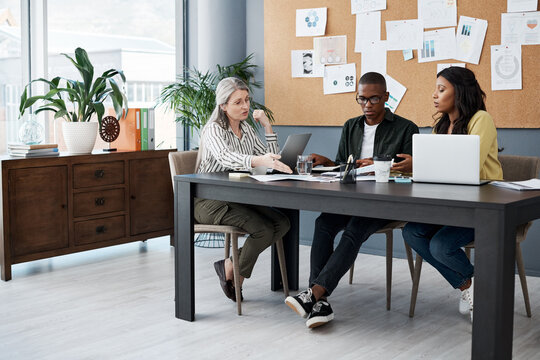 Office, desk and business people with laptop in meeting for sales review, planning and brainstorming. Advertising, team and employees with technology in collboration for kpi growth, analysis and idea