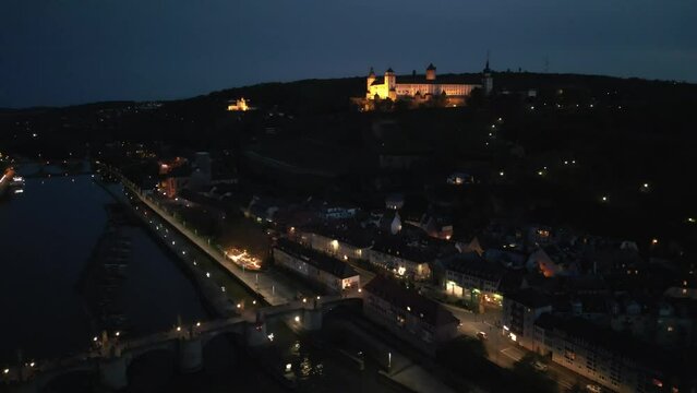 Aerial shot of the Old Main Bridge and Marienberg Fortress illuminated at night in Wurzburg, Germany